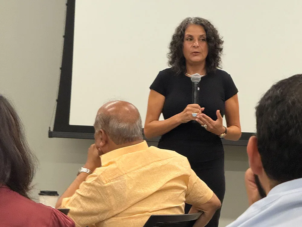 Jodee Blanco speaking with a microphone to a small audience